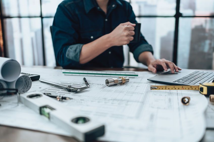 Joint pipe with drawings on the office desk and Calculator, triangle ruler, safety glasses, compass, vernier caliper on Blueprint. Engineer, Architect, Industry and factory concept.