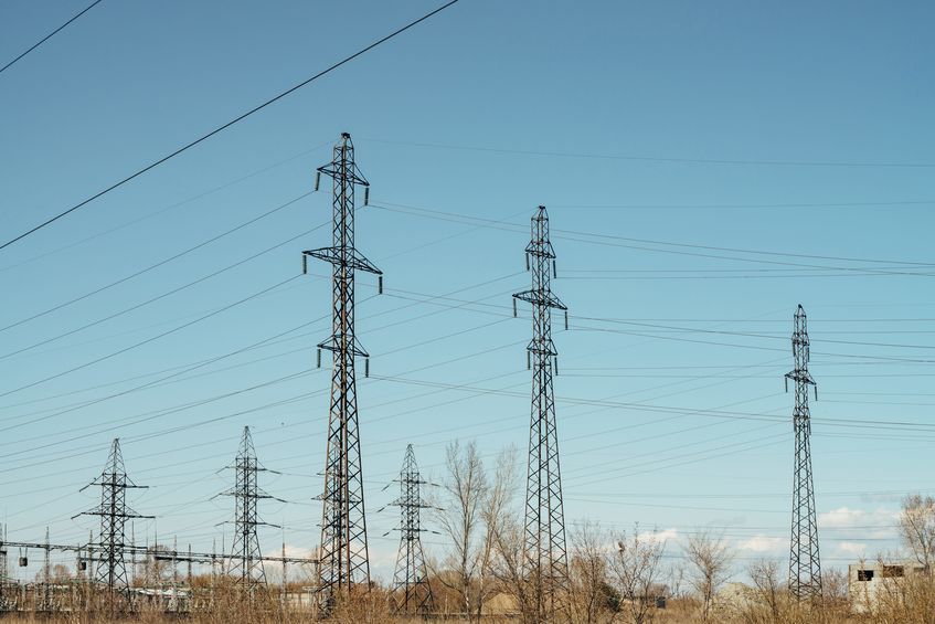 group of posts with wires of high voltage on background of blue sky. background image of pillars and wires in sky with copy space.